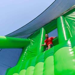 Photo of man jumping on giant inflatable slide